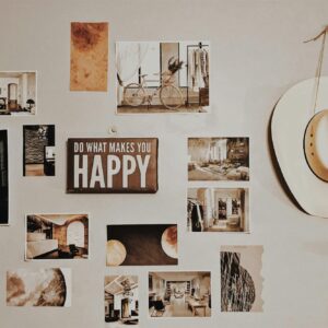 Gallery wall with photos, art, and an inspirational sign, featuring a cowboy hat.